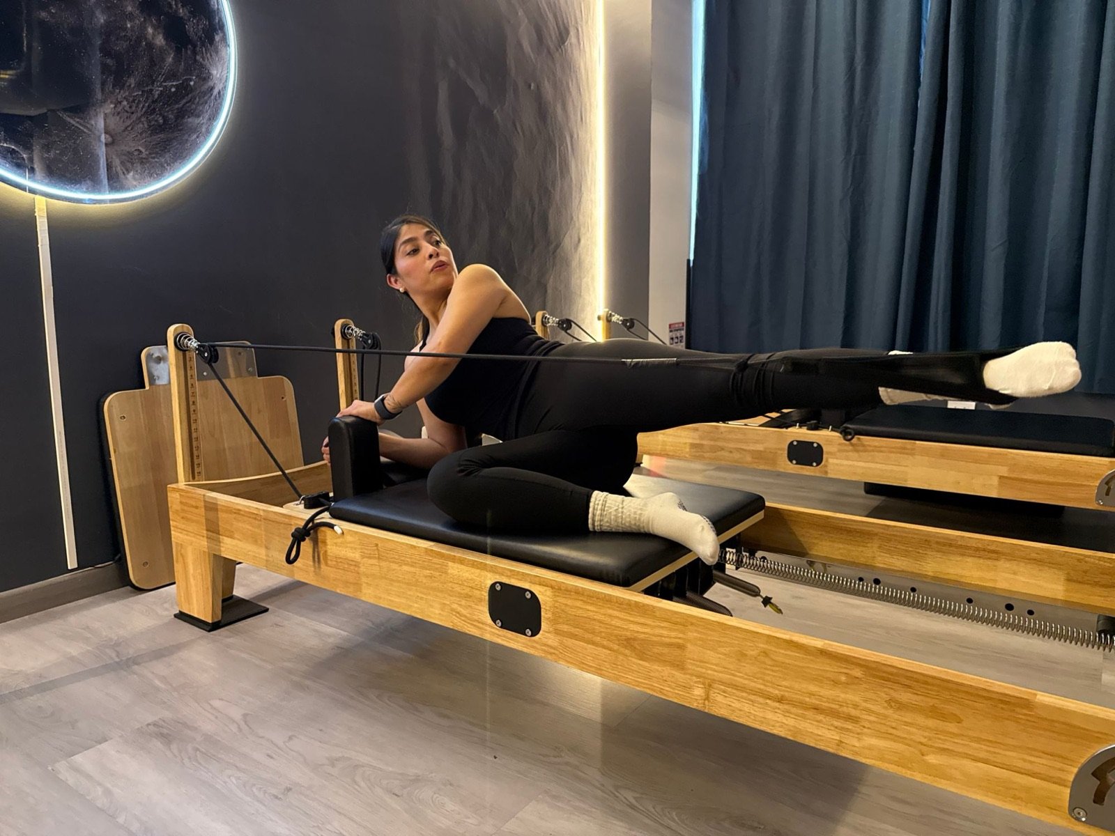 Ejercicio de pierna lateral con correas en Pilates Reformer, Cedritos
