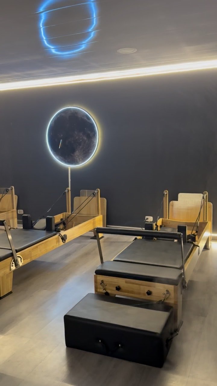 Recorrido por el estudio de pilates con la luna iluminada en la pared